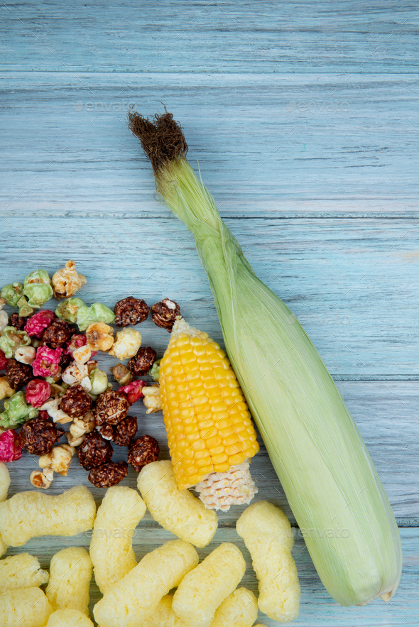 top view of cut corn and uncooked corn with skittles popcorn and corn